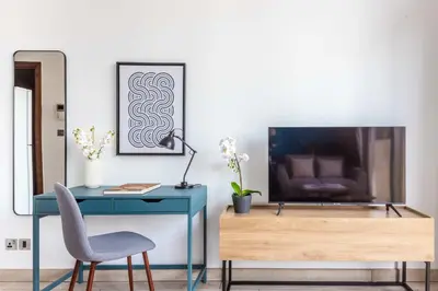 a blue desk with a television and a chair at Silkhaus elegant studio with Burj Khalifa view and balcony in Dubai