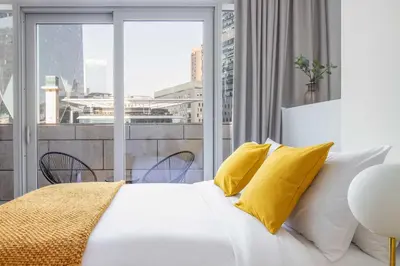 a bedroom with a white bed with yellow pillows at Silkhaus modern furnished studio in DIFC center with balcony in Dubai