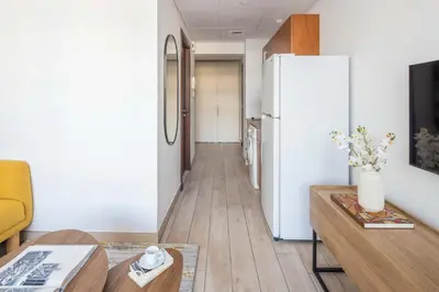 a living room with a refrigerator and a table at Silkhaus modern furnished studio in DIFC center with balcony in Dubai