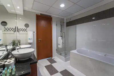 a bathroom with a tub and a sink and a bath tub at HiGuests - Luxury Apartment in the Iconic Park Towers in Dubai