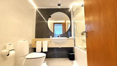 a bathroom with a toilet and a sink and a mirror at Trinity Holiday Homes - Sheikh Zayed Road Right Next to Financial Center Metro Station Exit 1 in Dubai