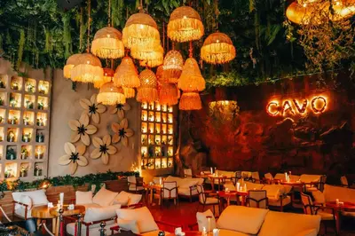 a restaurant with chandeliers and tables and chairs at Ramee Dream Hotel Downtown in Dubai