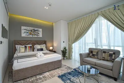 a bedroom with a bed and a couch and a chair at Luxury Escapes - Large Studio in the heart of Dubai Marina - West Avenue in Dubai