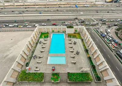 an overhead view of a building with a swimming pool next to a highway at Luxury Escapes - Large Studio in the heart of Dubai Marina - West Avenue in Dubai
