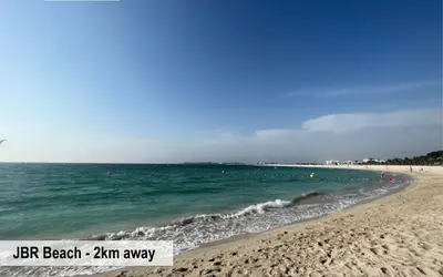 a beach with people swimming in the water at Luxury Escapes - Large Studio in the heart of Dubai Marina - West Avenue in Dubai