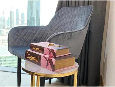 a stack of boxes sitting on a stool next to a chair at THE PENTHOUSE near Burj Khalifa and Dubai Mall in Dubai