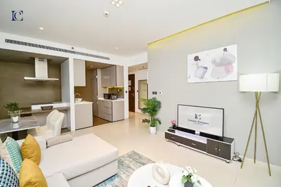 a living room with a white couch and a tv at Luxury Escapes - 1BR Apt with Balcony - West Avenue Marina in Dubai