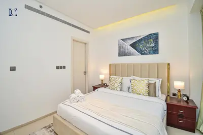 a bedroom with a large white bed and a window at Luxury Escapes - 1BR Apt with Balcony - West Avenue Marina in Dubai