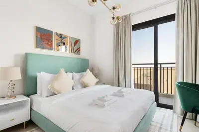 a bedroom with a bed with a green headboard and a window at GuestReady - The Wandering Oasis in Town Square in Dubai