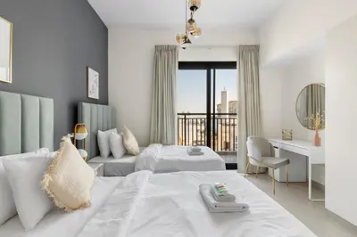 a hotel room with two beds and a balcony at GuestReady - The Wandering Oasis in Town Square in Dubai