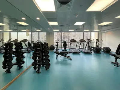 a gym with several rows of treadms and machines at GuestReady - The Wandering Oasis in Town Square in Dubai