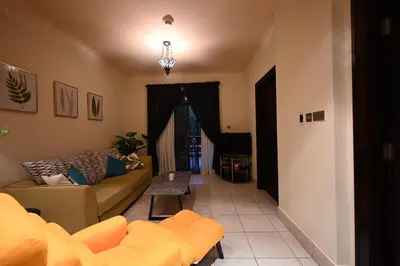 a living room with a couch and a table at Newly furnished. Cozy apartment. Quite location. in Dubai