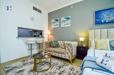 a living room with a couch and a chair at Luxury Escapes - New Lake View Studio in JLT - near Metro in Dubai