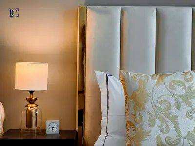 a bed with a lamp on a table next to a pillow at Luxury Escapes - New Lake View Studio in JLT - near Metro in Dubai