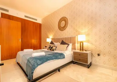 a bedroom with a bed and a night stand with a lamp at Hometown Apartments - Cosy 1 Br Apartment with Brand New Furniture in DIFC in Dubai