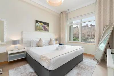 a bedroom with a large bed and a window at Welcoming 1 Bedroom Palm Jumeirah with sea View in Dubai
