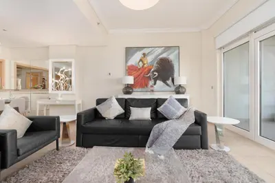 a living room with a black couch and a table at Welcoming 1 Bedroom Palm Jumeirah with sea View in Dubai