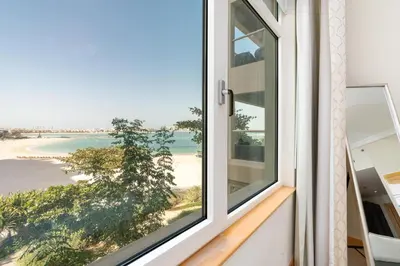 a window with a view of the beach at Welcoming 1 Bedroom Palm Jumeirah with sea View in Dubai