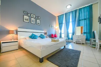 a bedroom with a large white bed and blue walls at Luxury Escapes - Studio near Ibn Battuta Mall & Metro - MOG 193 Discovery Gardens in Dubai
