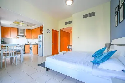 a bedroom with a large bed and a kitchen at Luxury Escapes - Studio near Ibn Battuta Mall & Metro - MOG 193 Discovery Gardens in Dubai
