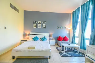 a bedroom with a bed with red and blue pillows at Luxury Escapes - Studio near Ibn Battuta Mall & Metro - MOG 193 Discovery Gardens in Dubai
