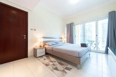 a bedroom with a bed and a large window at Luxury Escapes - Elegant and spacious 1bed with 2 balconies in JLT in Dubai