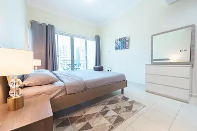 a bedroom with a bed and a large window at Luxury Escapes - Elegant and spacious 1bed with 2 balconies in JLT in Dubai