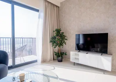 a living room with a tv and a large window at Nasma Luxury Stays - Elegant Condo With City Views And Dubai Skyline in Dubai