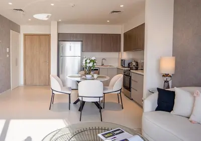 a kitchen and living room with a table and chairs at Nasma Luxury Stays - Elegant Condo With City Views And Dubai Skyline in Dubai
