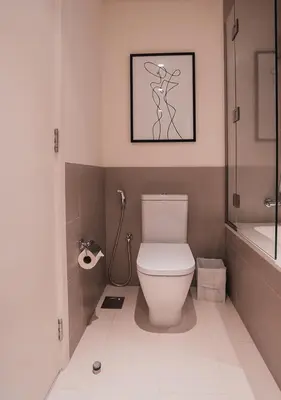 a bathroom with a toilet and a picture of a woman at Nasma Luxury Stays - Elegant Condo With City Views And Dubai Skyline in Dubai