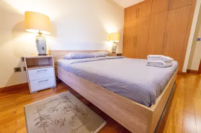 a bedroom with a large bed with two towels on it at Luxury Escapes - Stylish 1BR - Murad Tower - Close to the Emirates Mall in Dubai