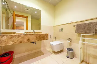 a bathroom with a sink and a toilet and a mirror at Luxury Escapes - Stylish 1BR - Murad Tower - Close to the Emirates Mall in Dubai