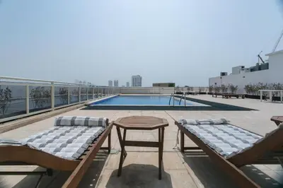 a patio with two chairs and a table and a pool at Luxury Escapes - Stylish 1BR - Murad Tower - Close to the Emirates Mall in Dubai