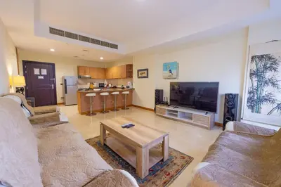 a living room with two couches and a large television at Luxury Escapes - Stylish 1BR - Murad Tower - Close to the Emirates Mall in Dubai
