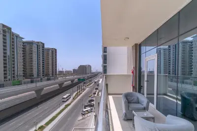 a balcony of a building with a view of a highway at Trinity Holiday Homes - Spacious Modern Living 1BR & 2BR Unique Apartment in Dubai