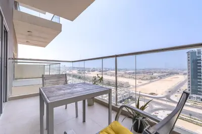 a dining room with a table and views of the city at Trinity Holiday Homes - Spacious Modern Living 1BR & 2BR Unique Apartment in Dubai