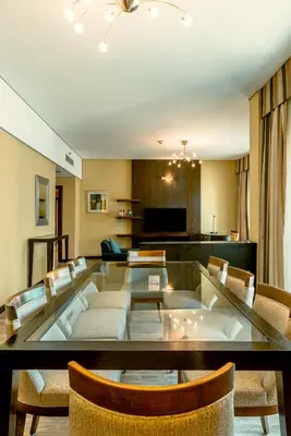 a living room with a glass table and chairs at TIME Oak Hotel & Suites in Dubai