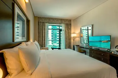 a bedroom with a large bed and a flat screen tv at TIME Oak Hotel & Suites in Dubai