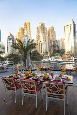 a table with food on top of a balcony with a city skyline at Signature Hotel Apartments and Spa in Dubai