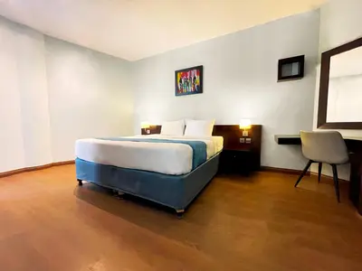 a bedroom with a bed and a desk and a chair at Signature Hotel Apartments and Spa in Dubai