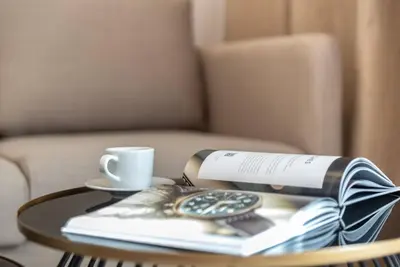 a table with a book and a cup of coffee and a book at Silkhaus modern studio with Burj Khalifa view in DIFC in Dubai