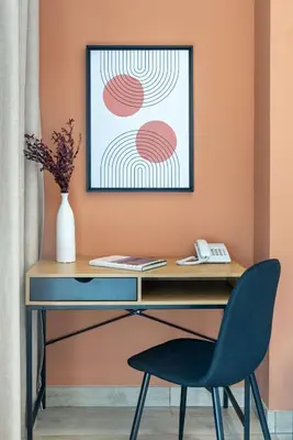 a desk with a chair and a picture on the wall at Silkhaus modern studio with Burj Khalifa view in DIFC in Dubai