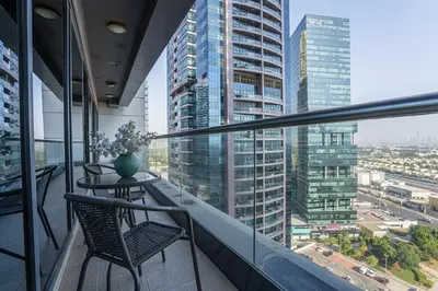 a balcony with a table and chairs and a city at HiGuests - Spacious Apartment Close to Dubai Marina Walk in Dubai
