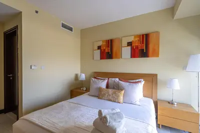 a bedroom with a bed and two night stands and two lamps at HiGuests - Spacious Apartment Close to Dubai Marina Walk in Dubai