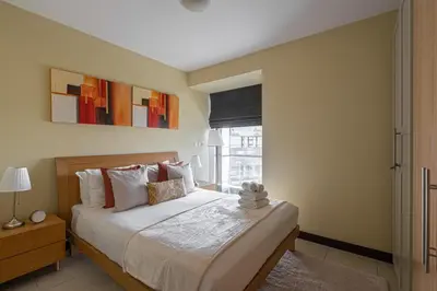 a bedroom with a large bed and a window at HiGuests - Spacious Apartment Close to Dubai Marina Walk in Dubai