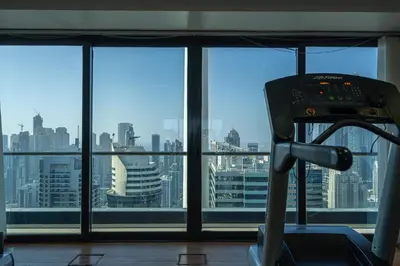 a gym with a view of a city from a window at HiGuests - Spacious Apartment Close to Dubai Marina Walk in Dubai