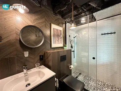 a bathroom with a sink and a shower with a mirror at HiGuests - Royal 2BR Apt with Maid's Room Near Burj Khalifa in Dubai