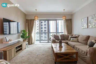 a living room with a couch and a tv at HiGuests - Royal 2BR Apt with Maid's Room Near Burj Khalifa in Dubai