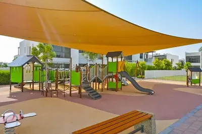 a park with a playground with a slide and a bench at Upgraded spacious 3BR+Maid Villa in Dubai