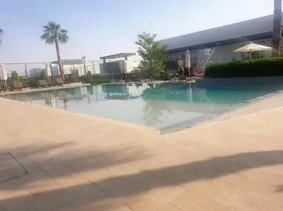 a large swimming pool in front of a building at Upgraded spacious 3BR+Maid Villa in Dubai